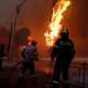 Firefighters and soldiers try to extinguish flames.